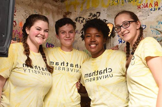 Photo of four students in matching yellow Chatham University shirts, 在Rea咖啡馆合影